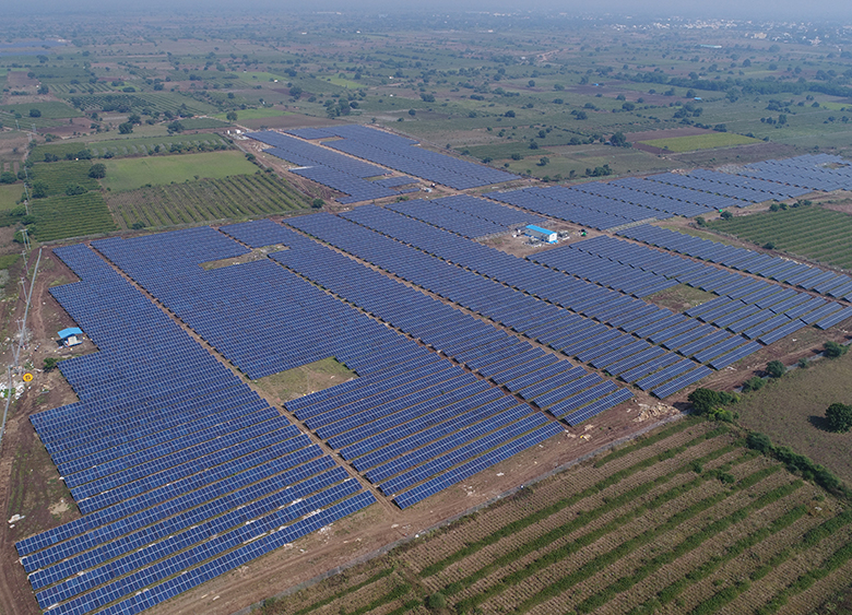 Vue aérienne d'un vaste champ de panneaux solaires dans un paysage agricole rural