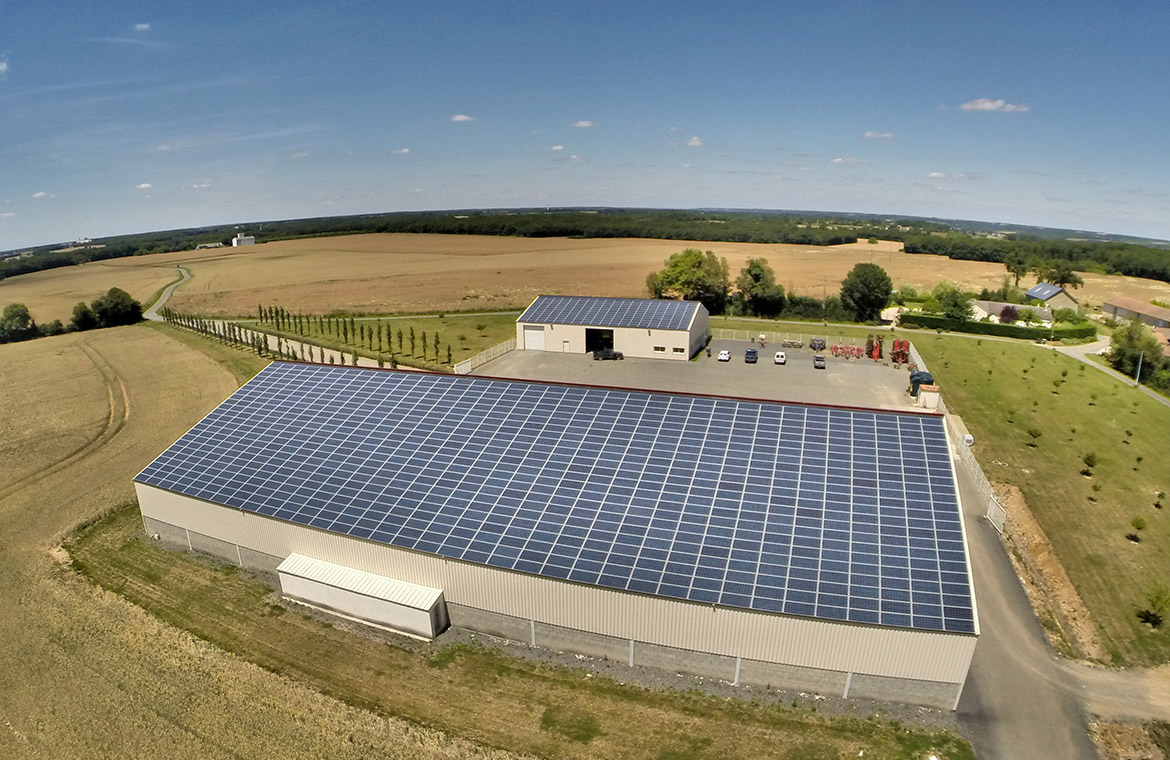 Installation solaire sur bâtiment agricole avec vue sur champs et bâtiments environnants