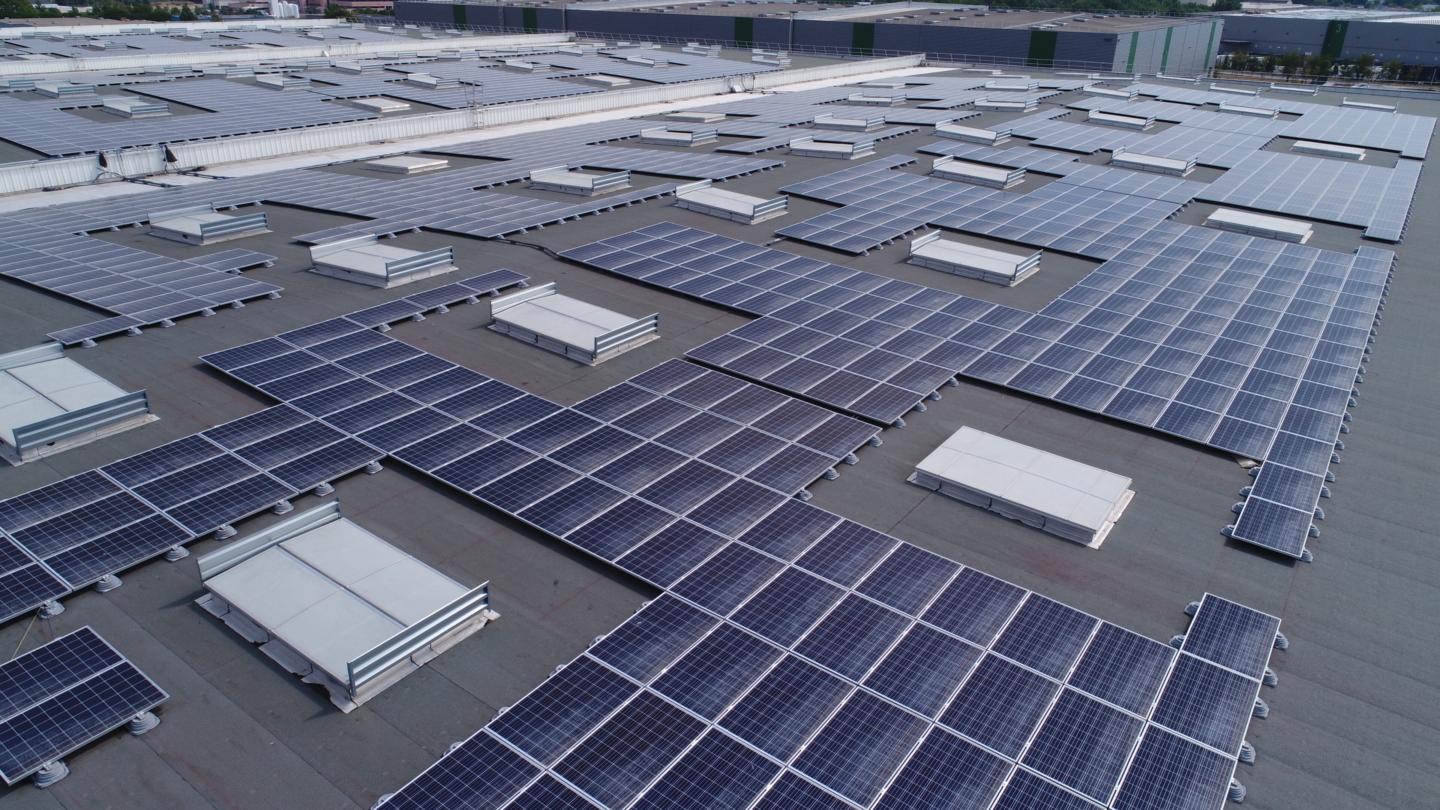 Installation de panneaux solaires sur une vaste toiture industrielle illustrant une solution de toiture photovoltaïque pour