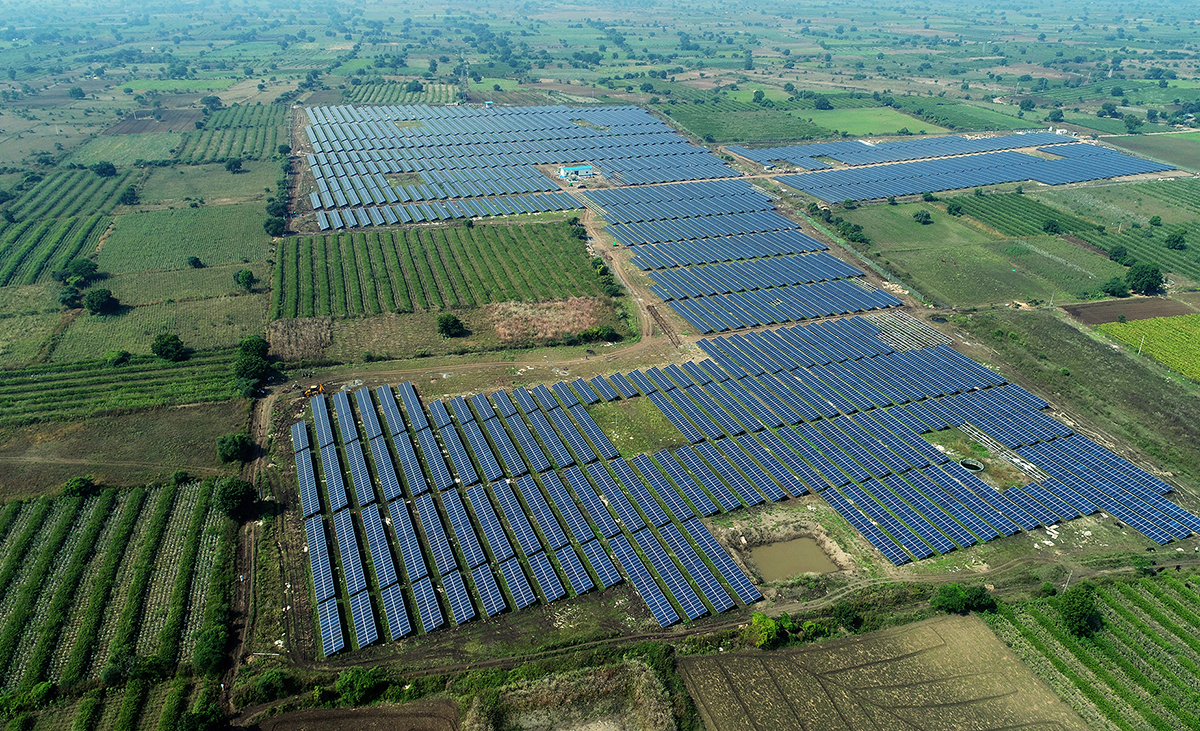 Vue aérienne d'un champ agricole avec des panneaux solaires disposés en parallèle parmi les cultures