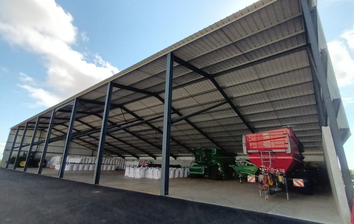 Abri agricole avec machine de récolte et silos de stockage de grains sous toit métallique