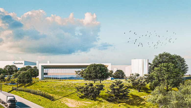 Bâtiment moderne avec logo Holosols entouré de verdure et de ciel dégagé avec un vol d'oiseaux en arrière-plan