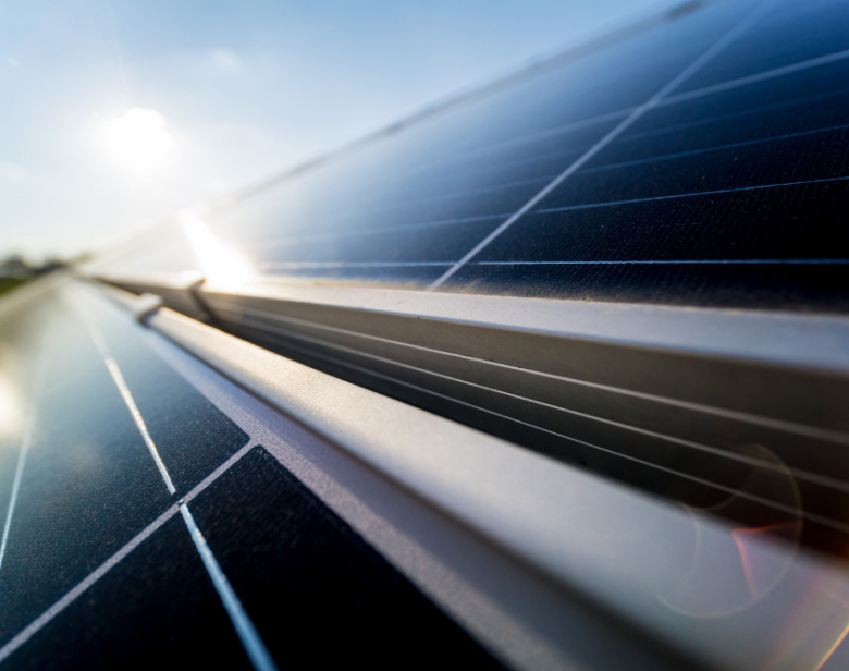 Panneaux solaires alignés sous un ciel ensoleillé avec reflets lumineux