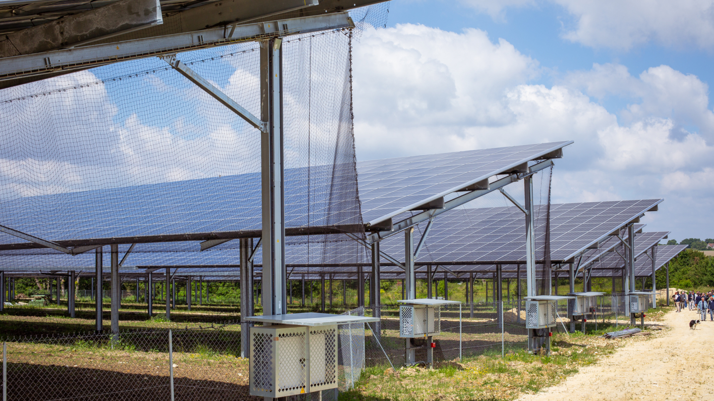 Installation solaire avec panneaux photovoltaïques sur structure métallique et clôture sécurisée en extérieur