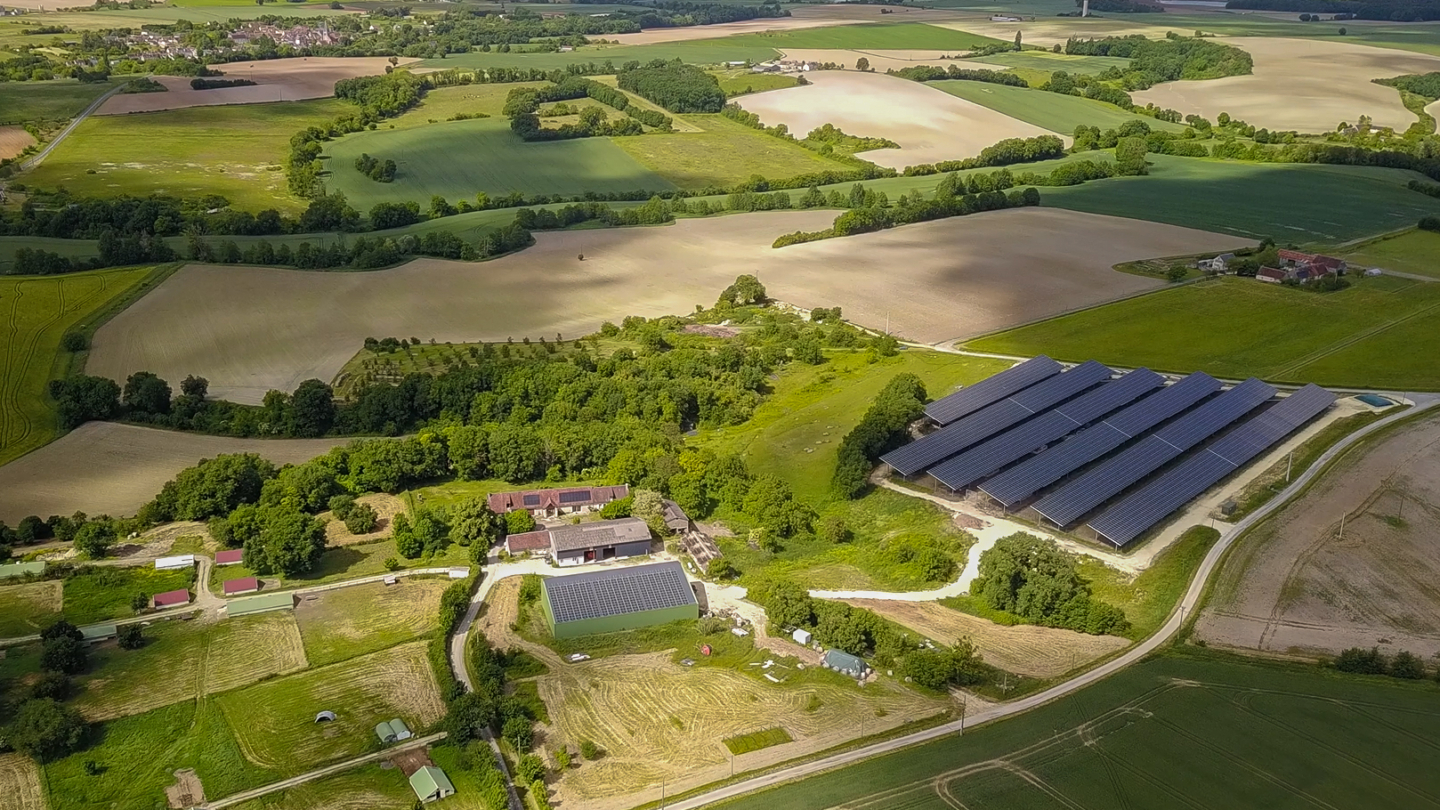 Ferme rurale équipée d'installations photovoltaïques intégrant des panneaux solaires sur les bâtiments et ombrières dan