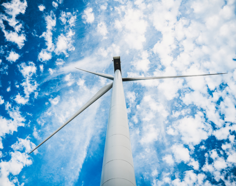 Éolienne vue de dessous avec ciel bleu et nuages floconneux