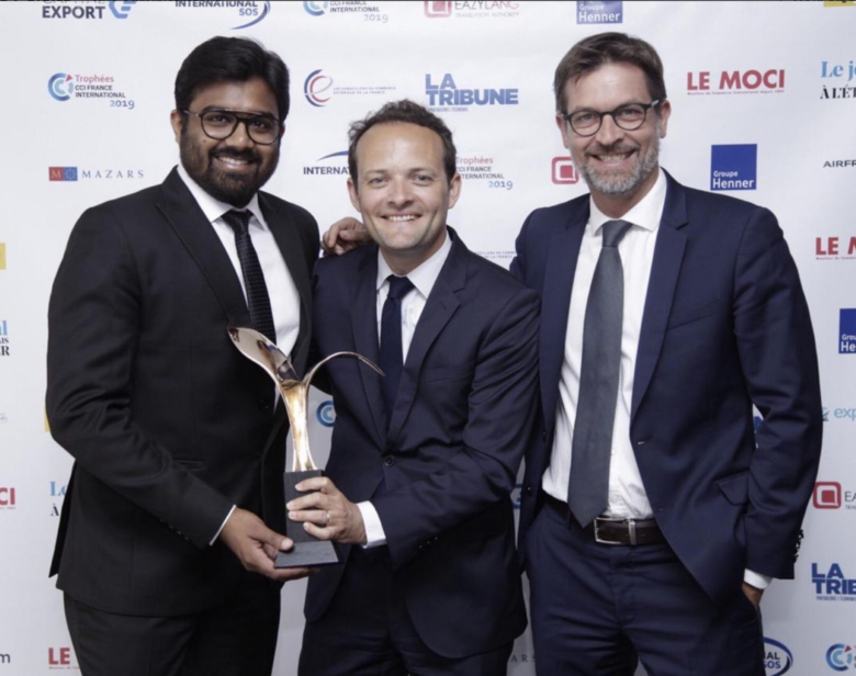 Trois hommes souriants posant avec une statuette lors d'une cérémonie internationale des trophées CCIFRANCE 2019