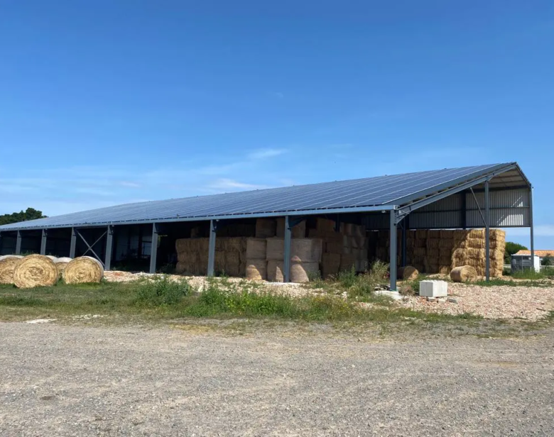 Bâtiment agricole abritant des balles de foin avec une toiture photovoltaïque couvrant l’espace de stockage pour une prod