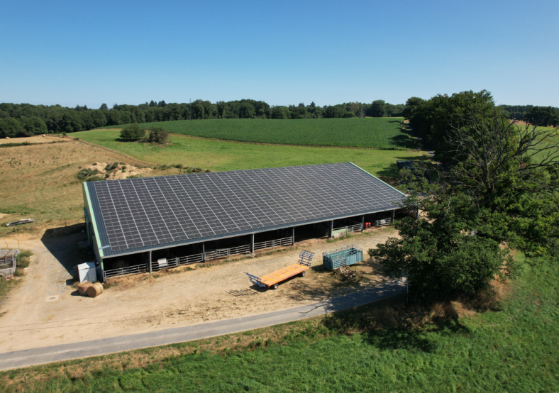 Ferme équipée d’une installation d’agrivoltaïsme combinant panneaux solaires et espace agricole dans un paysage rural