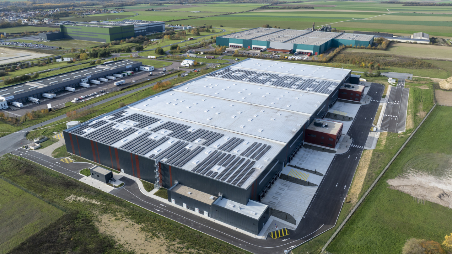 Vue aérienne d’un vaste complexe industriel avec des bâtiments de stockage et des entrepôts modernes en zone rurale ento