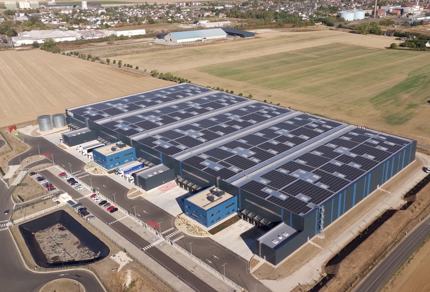 Usine moderne équipée d’une vaste installation de panneaux photovoltaïques sur sa toiture couvrant une grande surface in